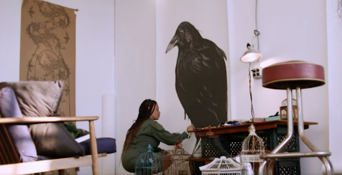 artist sabrina nelson adjusts an image of a large black bird