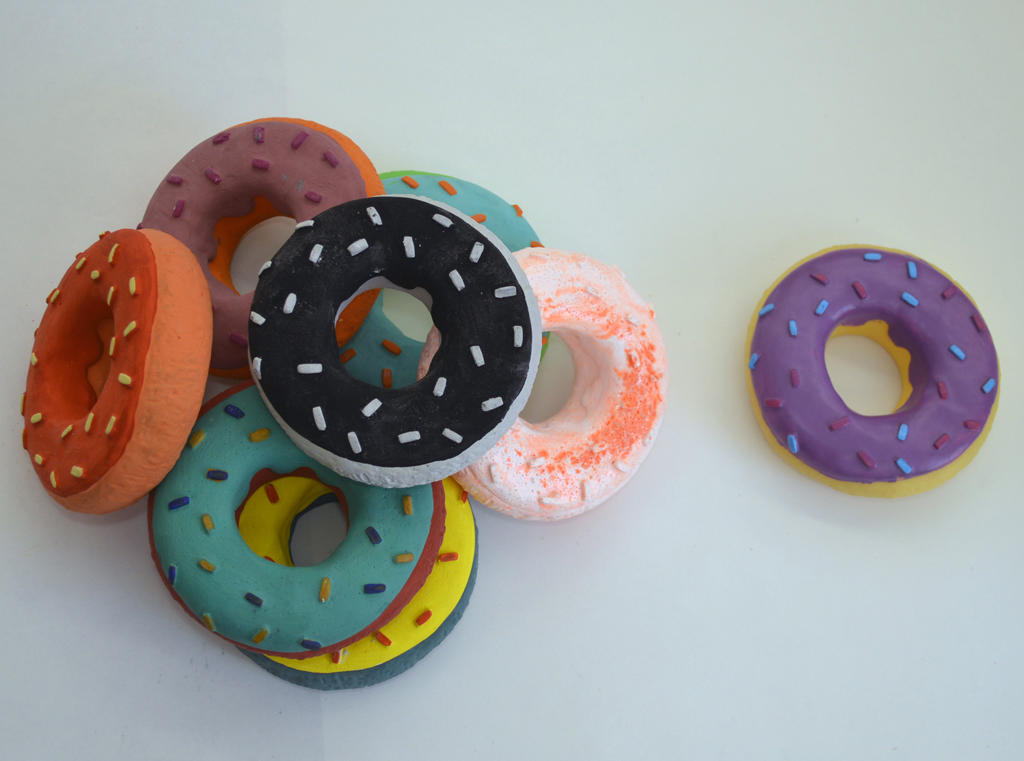 Marofske’s cast donuts, primarily plaster and gouache (L), and the original rubber donut dog toy (R). 