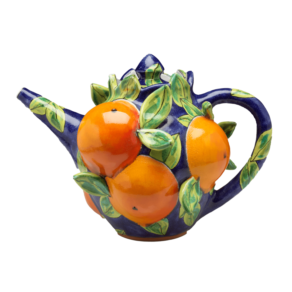 A dark blue teapot covered in oranges and green leaves in high relief.