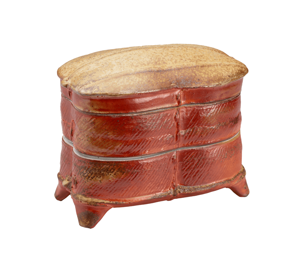 A rust-colored box with horizontal bands, triangular feet, and a tan top