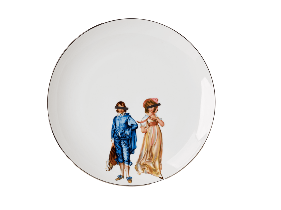 White circular plate with silver rim. Two figures at the lower center of the plate, one dressed in a blue outfit, the other in a pink dress, both with black, rectangular bars covering their eyes. 