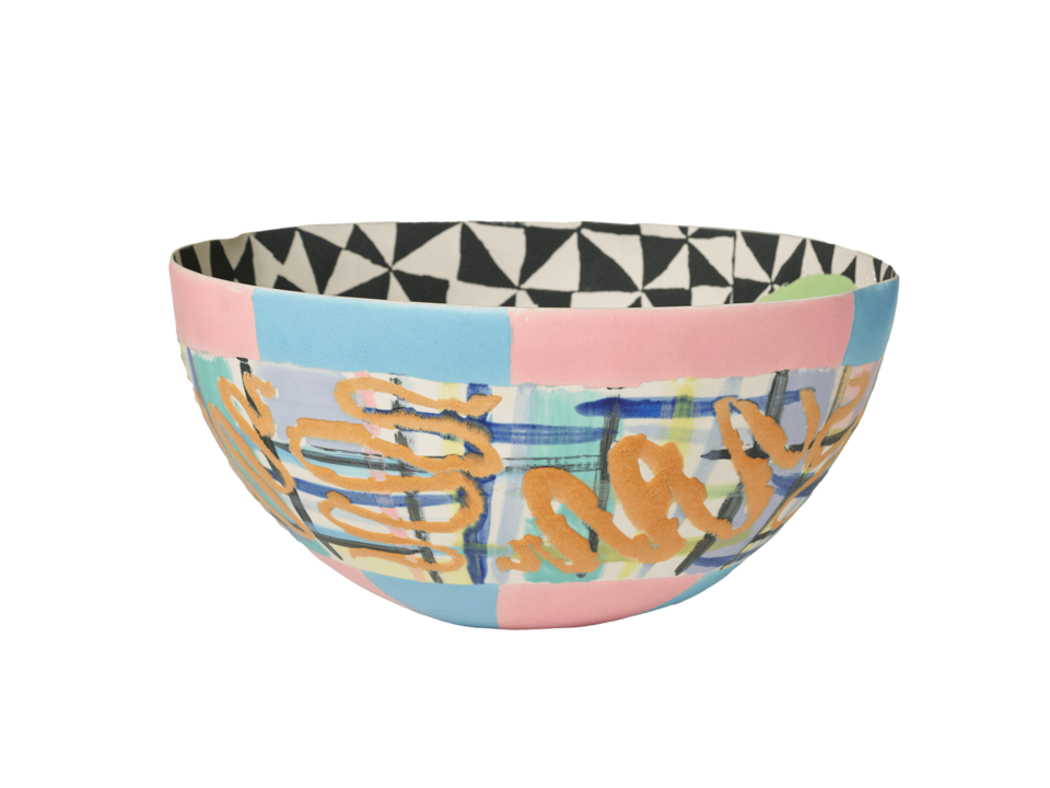 Bowl with multicolored lines and blocks of blue and pink at the top and bottom of exterior. Black and white geometric design on the interior. 