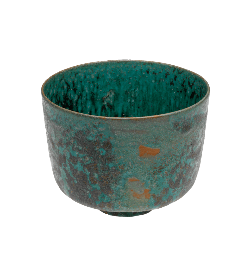 Thin-edged turquoise bowl, resting on a small round foot, with large splotches of dark blue on the sides. There are three small irregular orange marks in the center.