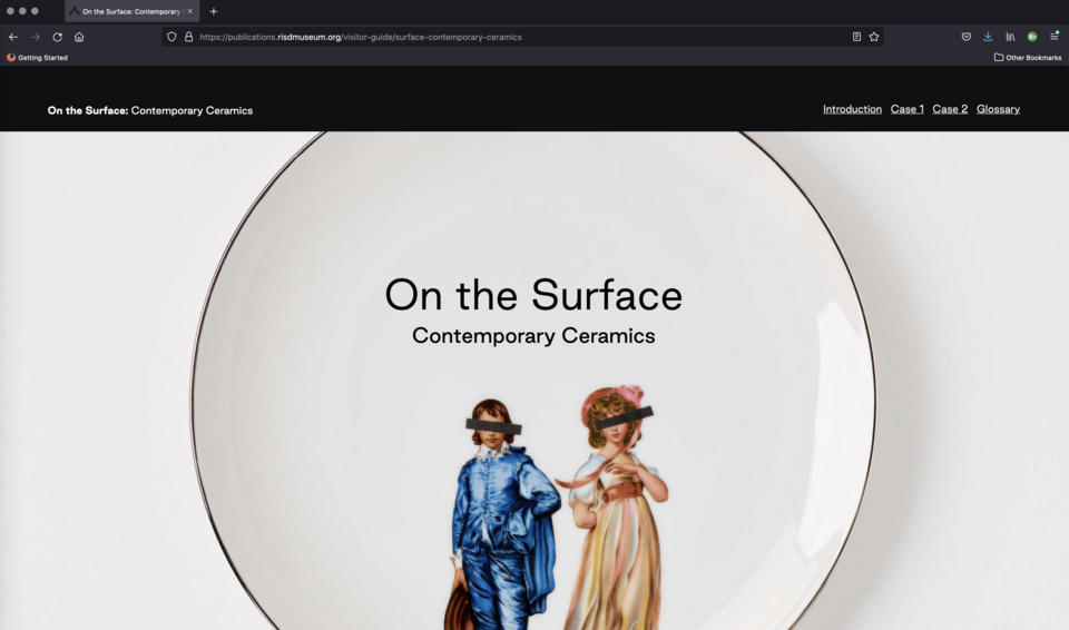 Screenshot. Text says “On the Surface: Contemporary Ceramics.” A white plate is decorated with two figures--a boy in blue and a girl in pink. Black bands cover their eyes. 