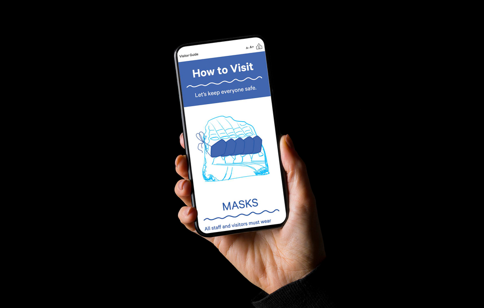 A light-skinned hand holds a cell phone. The phone’s screen says, in white and blue text: How to Visit: Let’s keep everyone safe. Masks: All staff and visitors must wear.”