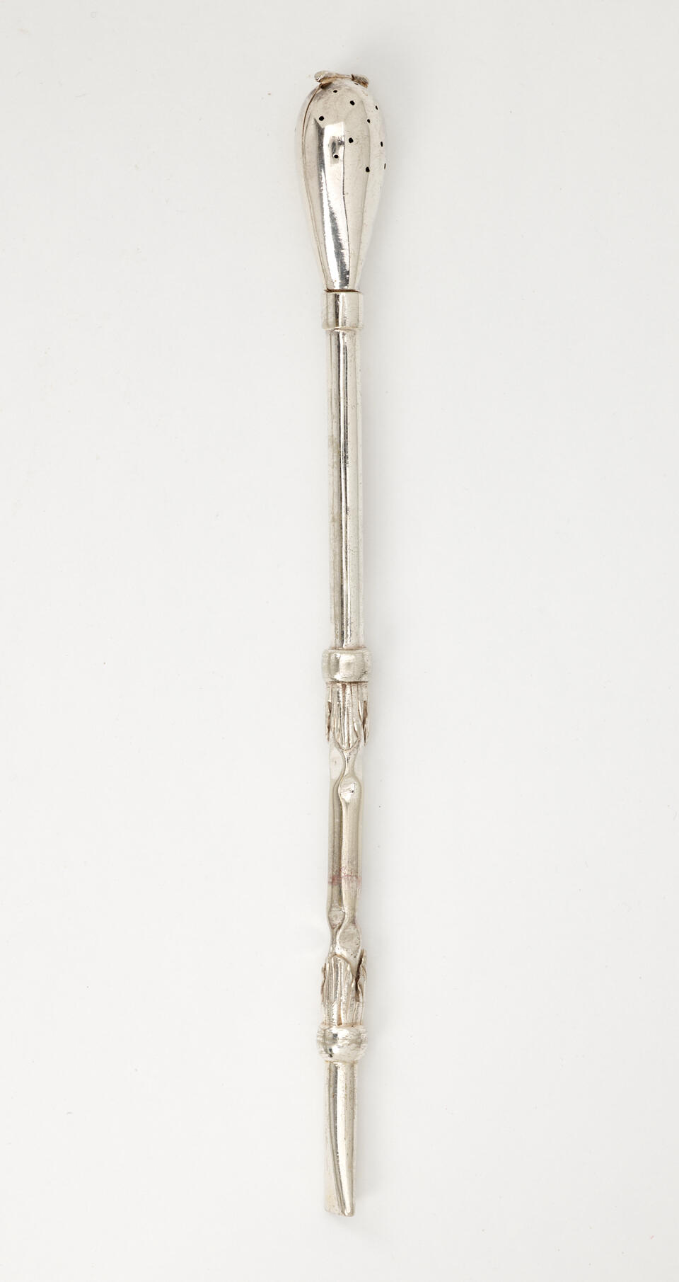 A silver utensil used for steeping tea with a long skinny handle and bulbous end with small holes.