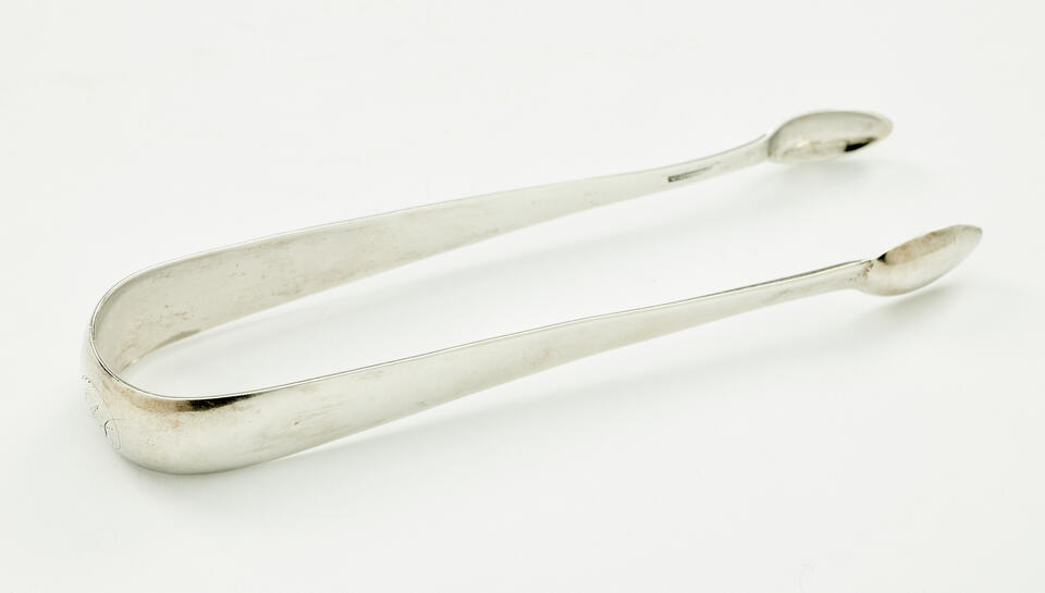 Silver sugar tongs with small ends and a thicker handle portion.
