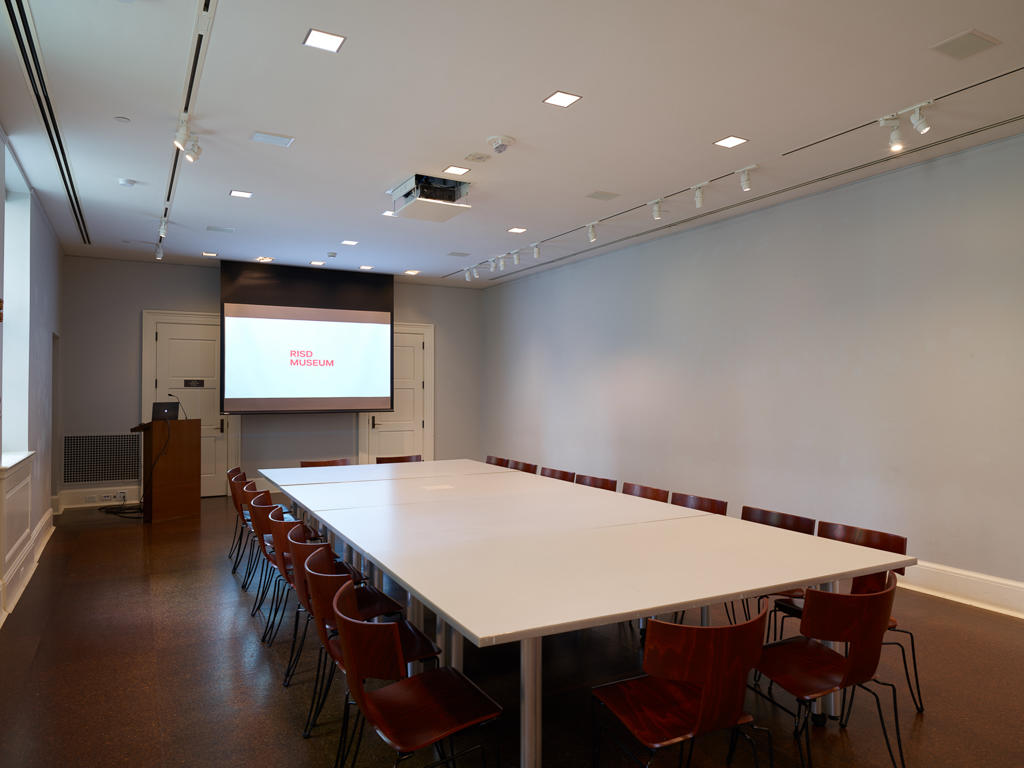 conference room with one large table surrounded with chairs and a projection screen