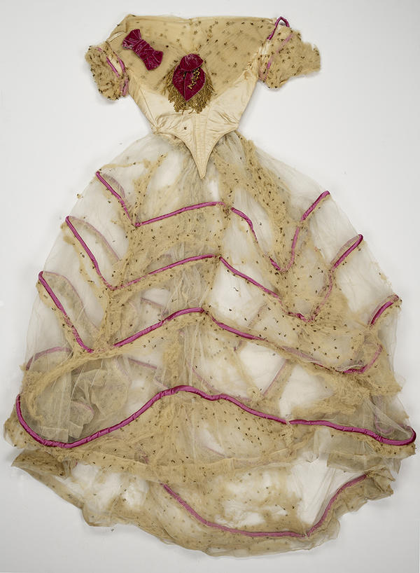 A tangled, very sheer, cream-colored long gown with short sleeves and a shiny bodice, shown from above. There are embellishments at the bustline and four dark pink bands on the skirt. 